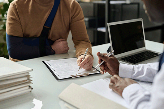 person with a cast signing a document person with a cast signing a document